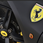 ferrari badge with black wheels in the background